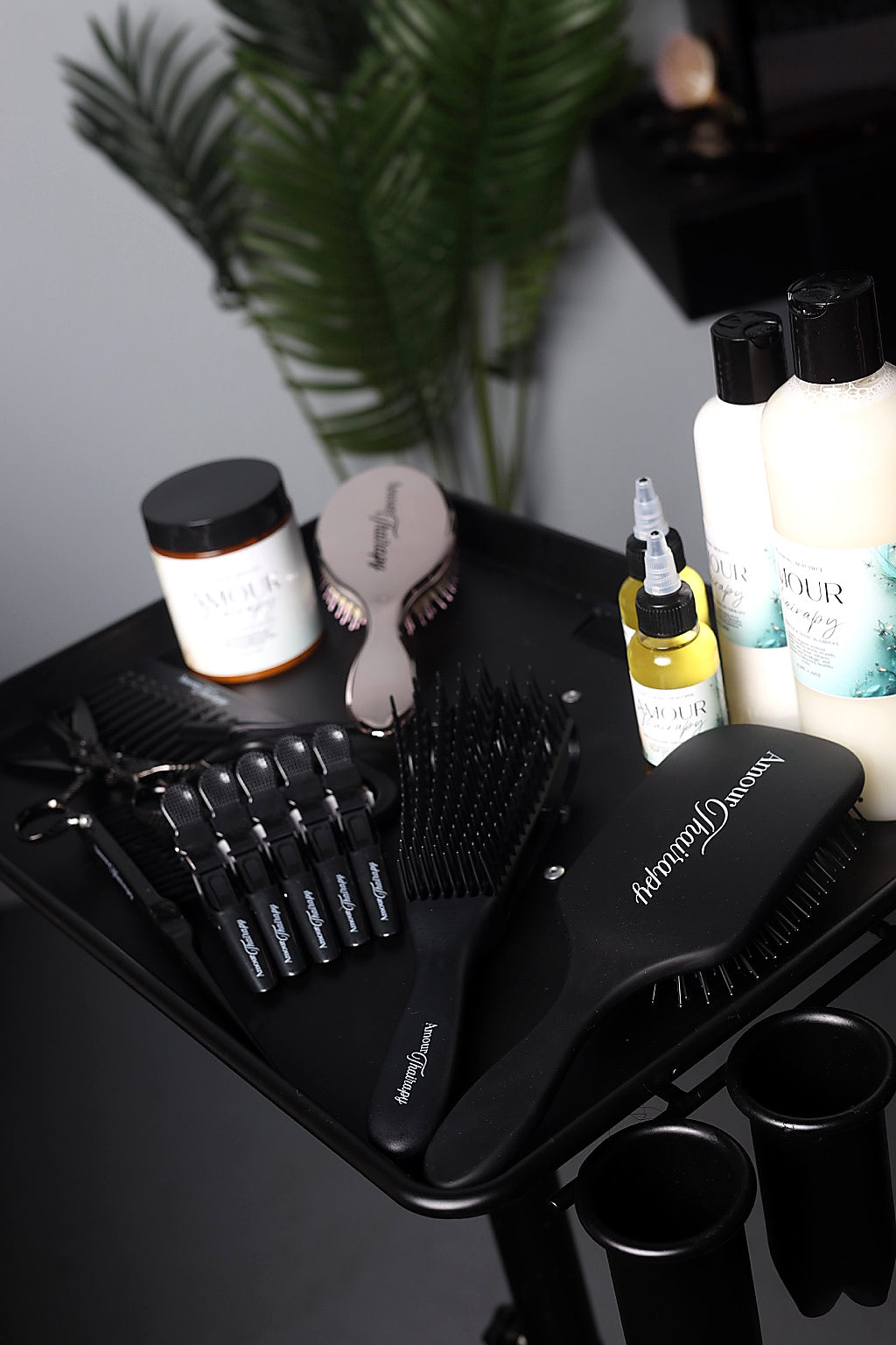 Amour Thairapy hair tools and hair care products displayed on a salon styling cart