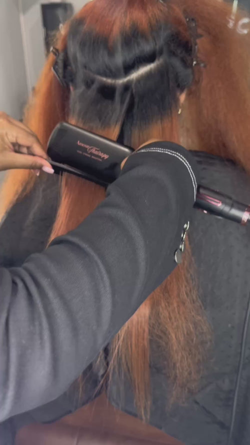 Stylist using Amour Thairapy 2-inch Titanium Flat Iron on hair.